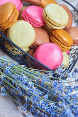 Fototapeta na wymiar Colorful french macaroons in a heart shaped basket