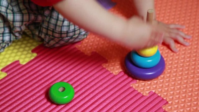 Bambino gioca a piramide, con numero otto, gioco d'incastro