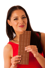 Beautiful young woman eats chocolate isolated over white backgro