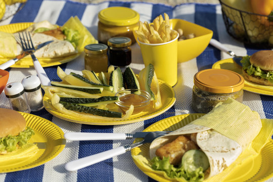 Summertime. A picnic on the beach. Burgers and pitas, vegetables