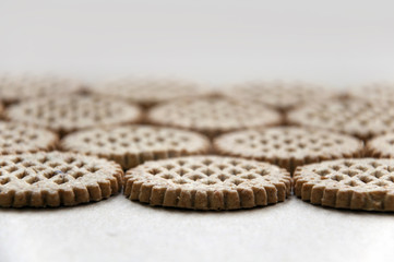 Food background. A lot round bran cookies laid out on a cardboard surface in perspective. Close up.