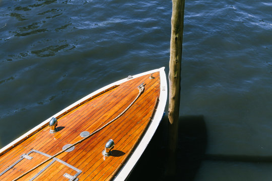 Detail of the wooden deck of a boat moored to a wooden stick