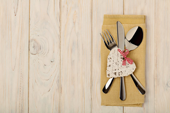Valentine's day concept. On the wooden table cutlery on linen na