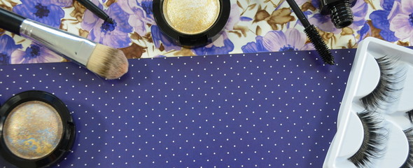 Косметика для макияжа с тенями для век и кистями на синем фоне с узором  - женская косметичка 