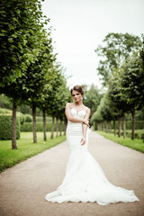 beautiful young bride standing in a park 