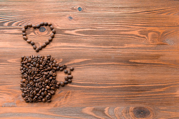 Coffee cup made from beans, grain with heart on wooden background. Valentine's Day or Wedding, love, black, frame. shaped . in shape of