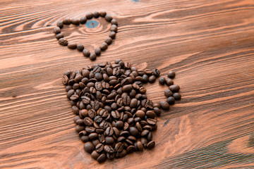 Coffee cup made from beans, grain with heart on wooden background. Valentine's Day or Wedding, love, black, frame. shaped . in shape of