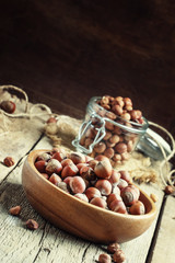 Raw hazelnuts in shell in a bowl on the old wooden background, s