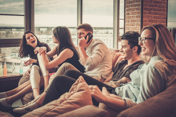 Group of multi ethnic young friends having fun in home interior