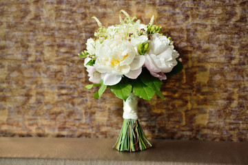 White natural wedding bouquet of peonies on brown background