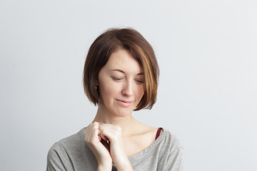 Shy and beautiful girl looks down bashfully, clutching something