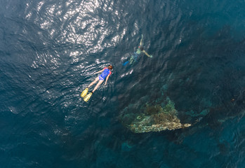 Aerial shot of the Japanese ship wreck with people snorkeling over it. Bali, Indonesia