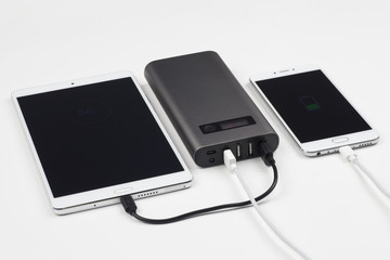 Powerbank charging tablet and smart phone.
