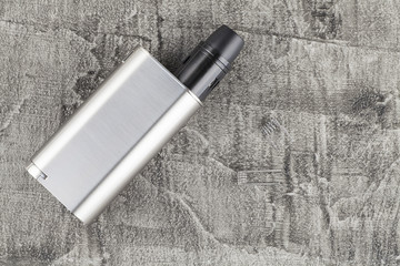 Modern vaping device on a concrete background.