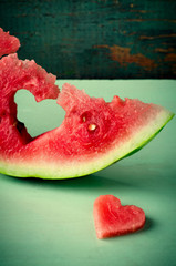 Fresh juicy watermelon heart at turquoise wooden background. Saint Valentine, love greeting card