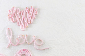 Word love made out of pink thread