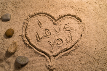 I love you and heart written in the sand