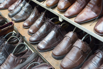 Closeup of shoes in second hand leather shoes shop. Many used sh
