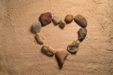 Heart arranged with stones on the sand
