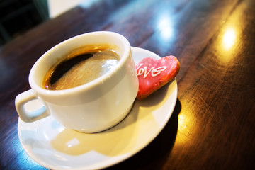 espresso, coffee beans and chocolate biscuit in a heart shape, close-up