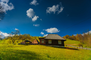 Traditional wooden house green field rural landscape, Carpathian mountains. Ukraine.