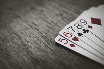 Poker Hands - Straight. Closeup view of five playing cards forming the poker straight hand. Texture added.