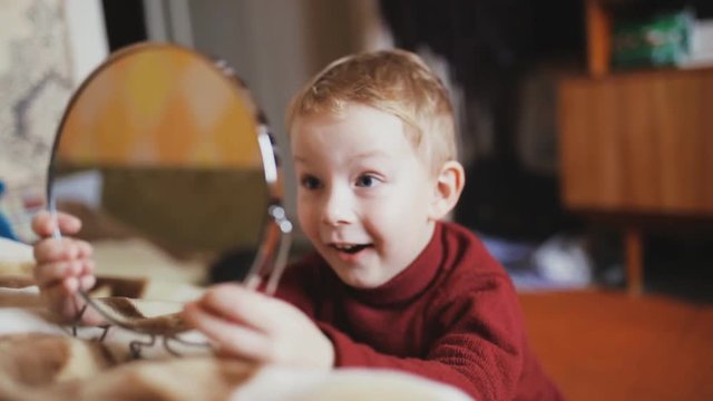 Boy playing with mirror in home room