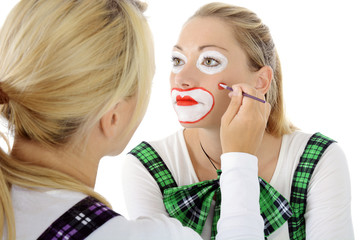 Frau oder Visagist schminkt Clown zu Karneval, Fasching oder Fastnacht 