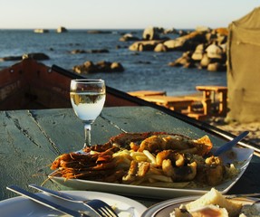 glass of white wine and plate seafood, selective focus