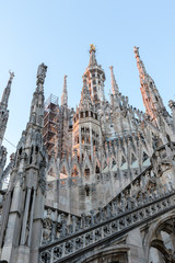 Naklejka premium Details of marble spiers and statues of Milan Cathedral, Italy, at sunset.