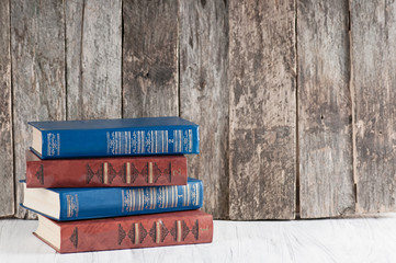 pile of old books on a wooden retro background and a white worktop