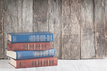 pile of old books on a wooden retro background and a white worktop