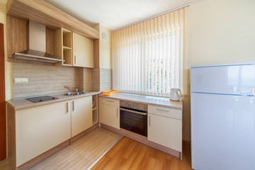 New wooden kitchen interior with appliances.