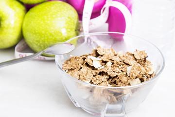 bowl of cereal with fruit, weights and tape measure and concept of diet and healthy living