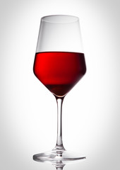 Glass of red wine with reflection on white
