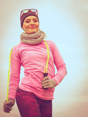 Woman training outdoor with jump rope on cold day