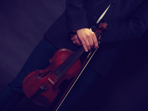 Man man dressed elegantly holding violin