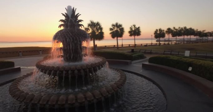 Cinematic aerial perspective of the iconic Pineapple Fountain and a cruise ship docked in Charleston, SC.