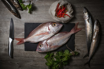 top view of fresh fishes and spices with raking light