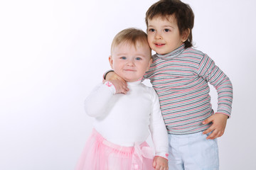 two cute hugging children on white