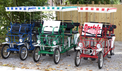 Fototapeta na wymiar Tricycle vacation rental carts with colorful canopies. Horizontal.