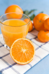 Fresh orange juice in a glass on a background of fruit baskets