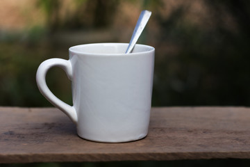 Hot coffee in a white cup on a wooden table.