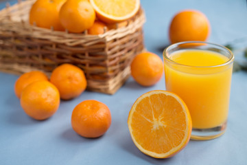 Fresh orange juice in a glass on a background of fruit baskets