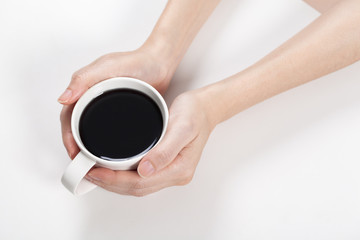 girl holding a cup of black coffee in hand.