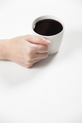 girl holding a cup of black coffee in hand.