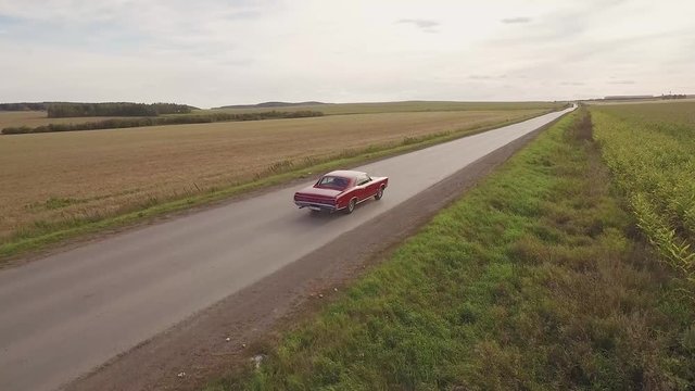 Cadillac riding along a corn field