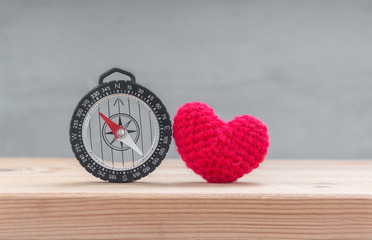 Red heart shape silk with compass on wood table