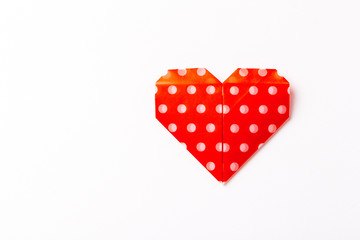 red origami paper heart on white paper background