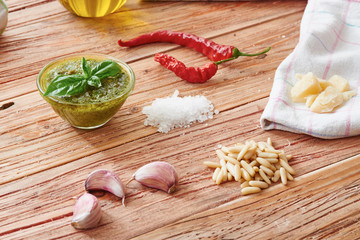 Table with various ingredients and pesto sauce